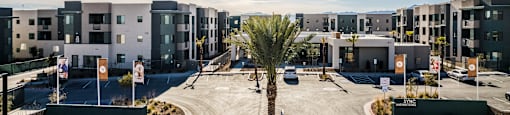 an empty parking lot in front of a row of apartment buildings at SYNC APARTMENT HOMES, Nevada