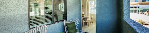 a balcony with two chairs and a table at SYNC APARTMENT HOMES, Nevada, 89084