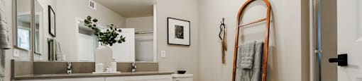a bathroom with white cabinets and a mirror and a toilet at SYNC APARTMENT HOMES, North Las Vegas, NV 89084