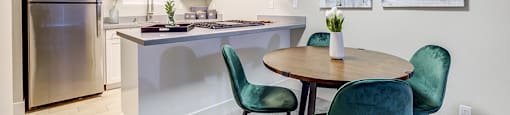 Dining table next to kitchen with appliances at The Edge on the Boulevard, Fremont, CA 94555