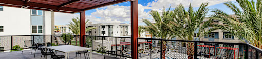 a rooftop patio with tables and chairs and a pool at BASE APARTMENT HOMES, LAS VEGAS, NV