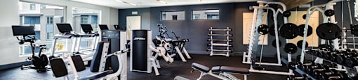 a gym with weights and other exercise equipment at BASE APARTMENT HOMES, LAS VEGAS, NV
