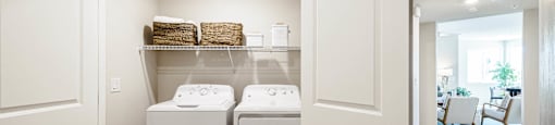 a washer and dryer in a laundry room with white doors at BASE APARTMENT HOMES, Nevada
