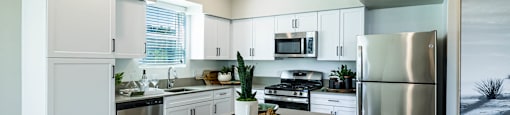 a kitchen with stainless steel appliances and white cabinets at BASE APARTMENT HOMES, LAS VEGAS, NV 89166