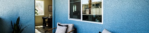 a living room with a blue wall and a large window at BASE APARTMENT HOMES, LAS VEGAS, 89166