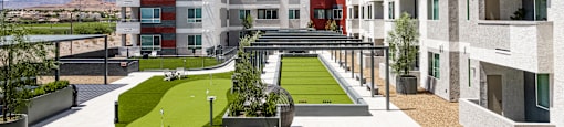 A modern residential area with apartment buildings and a green lawn.