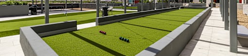 A modern outdoor area with a grassy area and a building in the background.