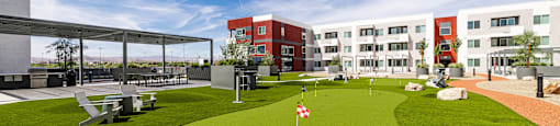 A small putting green in front of a building.