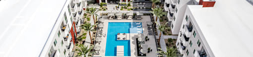 A swimming pool in the middle of a courtyard surrounded by buildings.