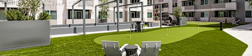 A modern building with a grassy courtyard and two chairs.
