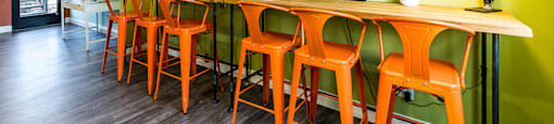 a long bar with chairs and a tv on the wall at Mountain Run Apartments, Orem