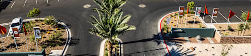 an aerial view of a parking lot with apartment buildings and palm trees