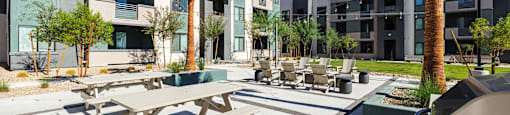 a communal communal area with picnic tables and chairs at an apartment building