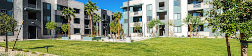a view of a grassy area with apartment buildings