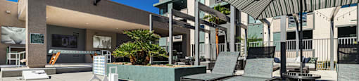 a patio with a table and chairs and a building in the background