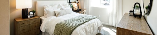 a bedroom with a bed and a dresser and a window