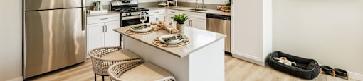 a kitchen with stainless steel appliances and a island with two stools