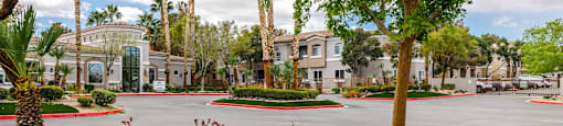 a street view of a parking lot with trees and gravel at THE CLUBS AT RHODES RANCH APARTMENT HOMES, Las Vegas, NV