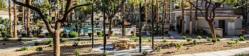 A park with trees and benches in the foreground.