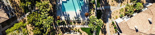 A swimming pool surrounded by trees and buildings.