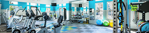 A gym with a variety of equipment including treadmills, exercise bikes, and weightlifting machines.