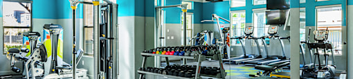 A gym with a variety of equipment including weights and machines.