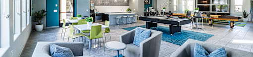 A spacious room with grey and blue furniture.