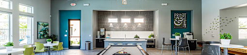 A billiard table is in the middle of a room with a blue carpet.