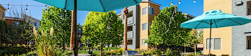 A patio with a table and chairs under a blue umbrella.