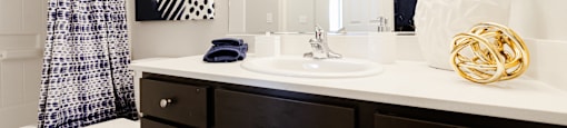 A bathroom with a toilet, sink, and mirror.