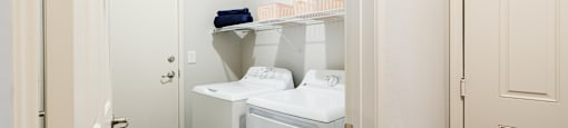 A small laundry room with a washer and dryer.