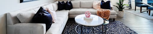 A living room with a white couch, a coffee table, and a painting on the wall.
