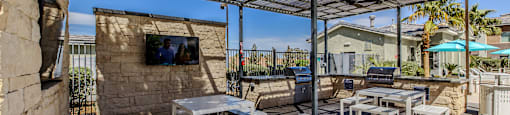A patio with white furniture and a stone wall.