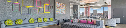 A modern living room with a grey sofa and yellow rug.