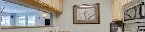 Spokane, WA Apartments With In-Unit Washer And Dryer - Deer Creek - Kitchen With Beige Countertops, Stainless Steel Appliances, and Wood-Tone Cabinetry.
