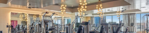 A gym with a variety of equipment and a ceiling fan.