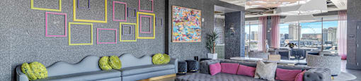 A modern living room with a grey sofa and a yellow rug.