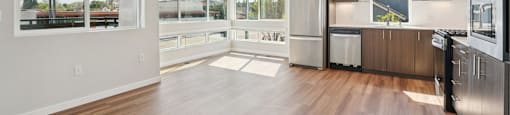A spacious kitchen with wooden floors and modern appliances.
