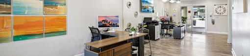A reception area with a wooden desk and a painting on the wall.