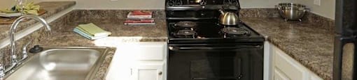 a kitchen with a black stove top oven next to a sink