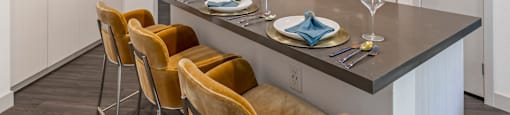 A modern kitchen with a dining table set for two.