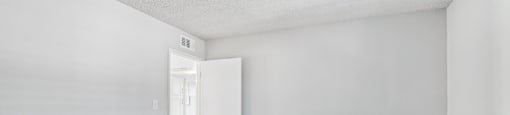 A white room with a doorway leading to another room.
