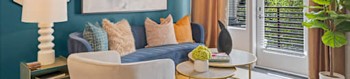 A living room with a blue couch and a white chair.
