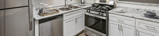 A kitchen with a refrigerator, stove, and sink.
