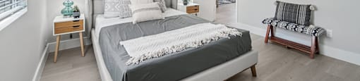A bedroom with a large bed and two nightstands.