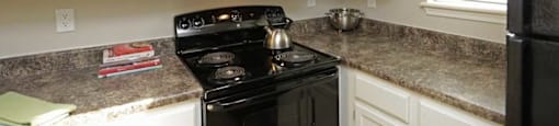 a kitchen with white cabinets and a black stove top oven