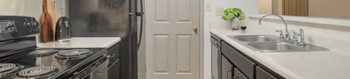 Kitchen with black appliances and ample cabinetry at Place at Midway apartments in Douglasville near Lithia Springs, GA