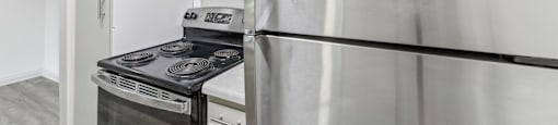 A kitchen with a stainless steel refrigerator and stove.