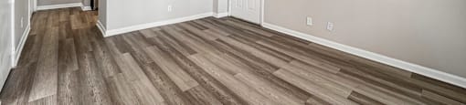 A room with wooden flooring and white walls.