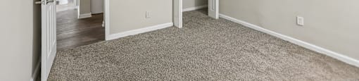 A room with a carpeted floor and a white door.